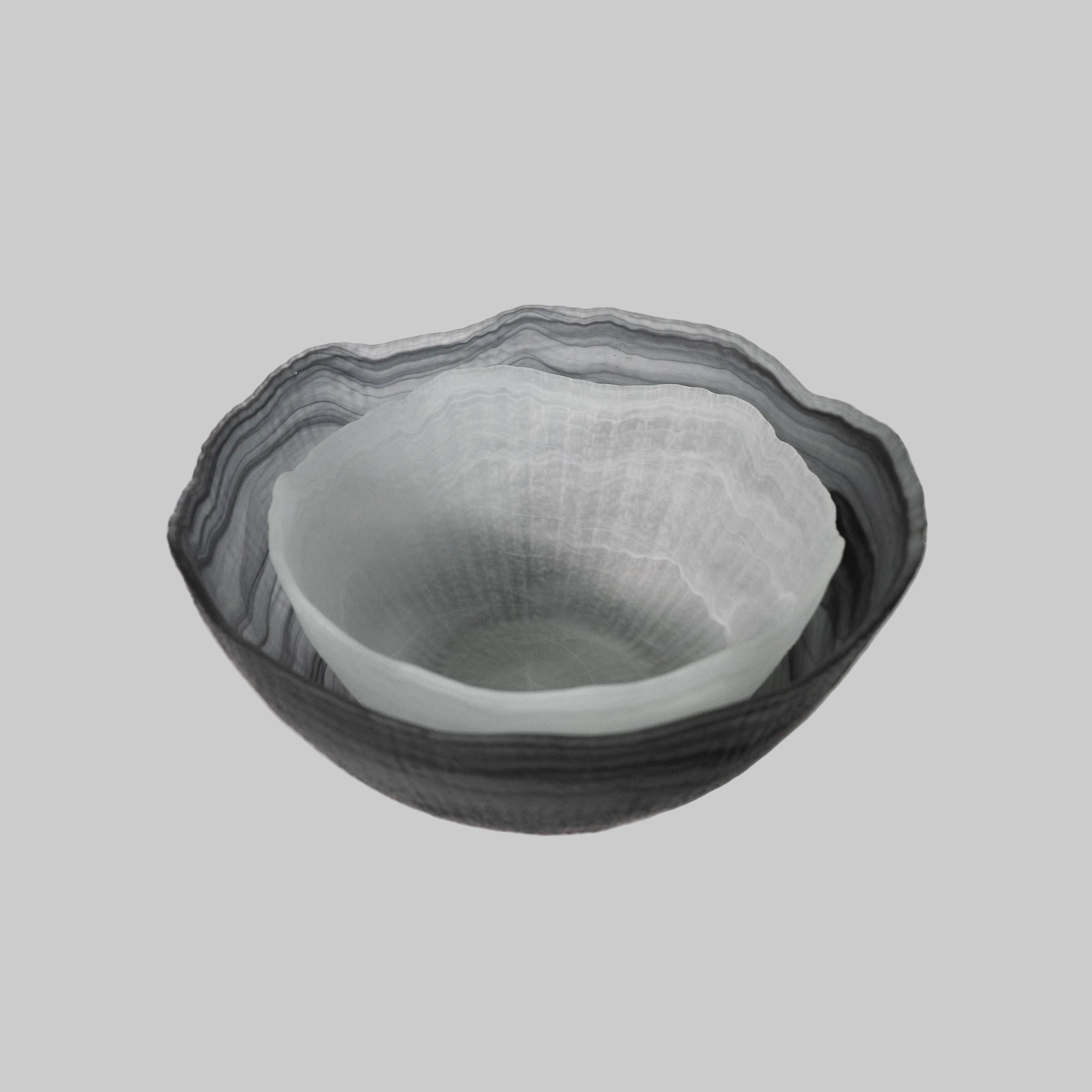 A collection of sculptural glass bowls, showcasing unique shapes and vibrant colors, elegantly arranged on a decorative surface."